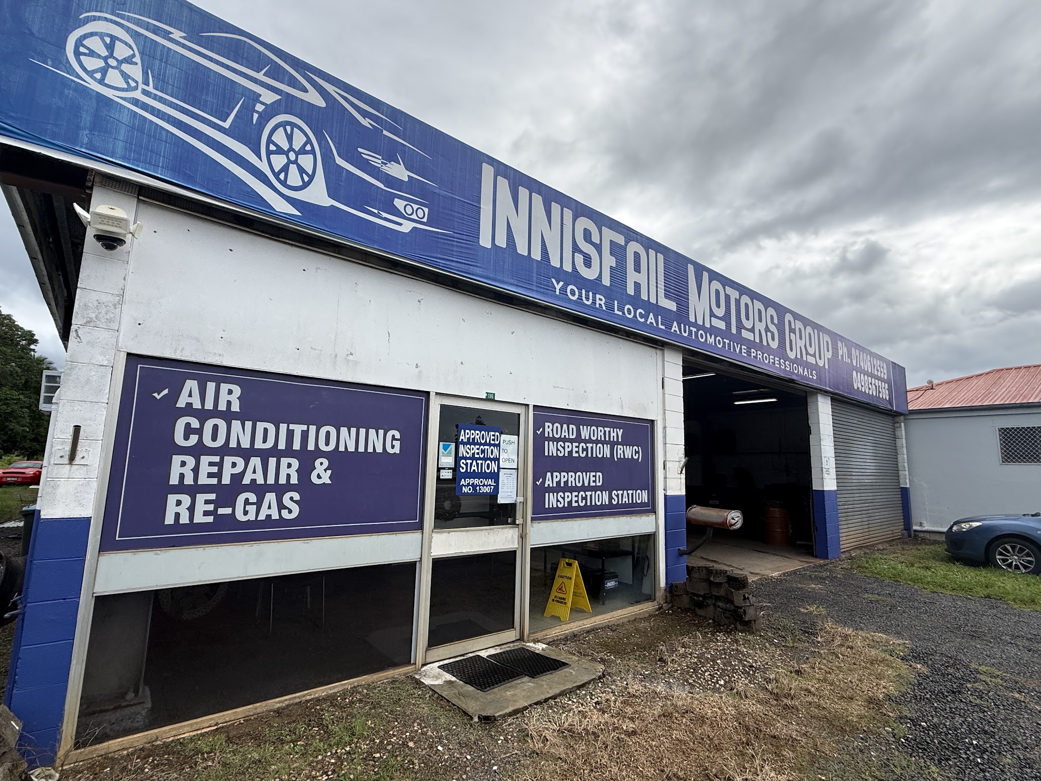 The Innisfail Motors Group shopfront showing the approved inspection station certificate and window signage